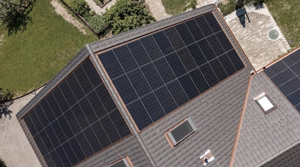 Draufsicht aus der Vogelperspektive auf ein Haus mit Garten und montierter PV-Anlage.