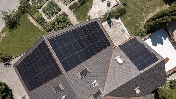 Draufsicht aus der Vogelperspektive auf ein Haus mit Garten und montierter PV-Anlage.