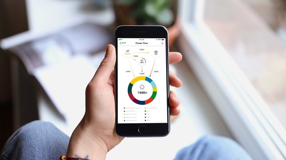 Eine Hand hält ein Smartphone auf dem die Home Energy App geöffnet ist.