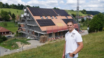 Remo Käser vor Haus mit Solaranlage