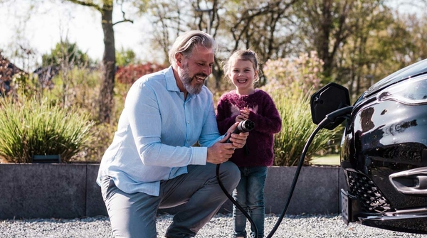 Vater und Tochter laden Elektroauto auf