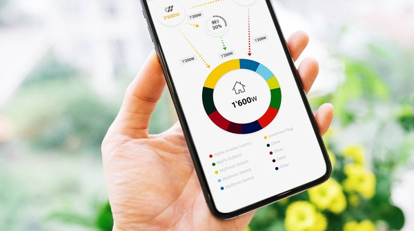 Eine Hand hält ein Smartphone und liest in der Home Energy Connect App nützliche Daten ab.