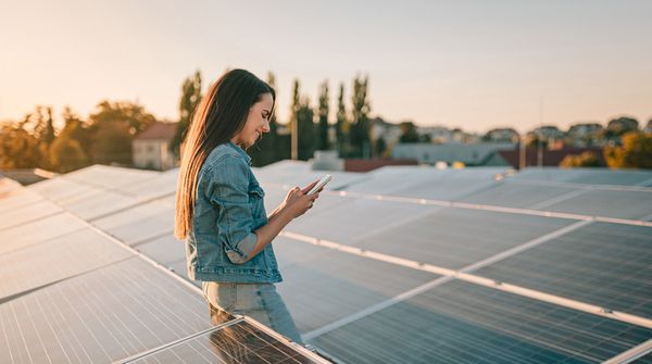 Frau auf Dach mit Solarpanels