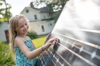 Mädchen steht vor PV-Modul